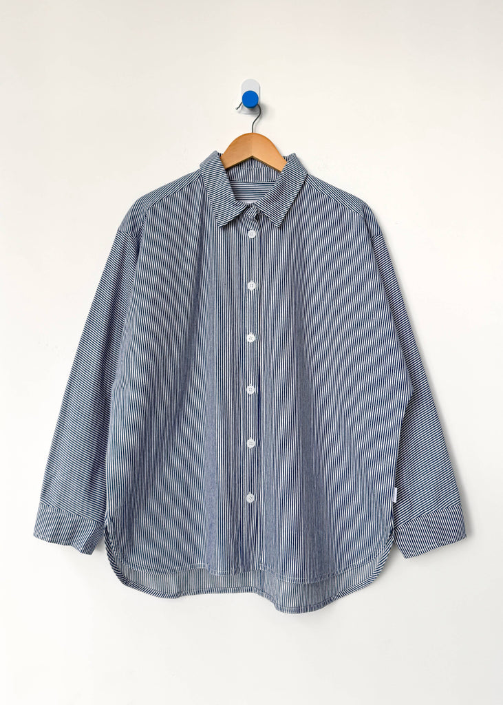 Blue striped shirt on a wooden hanger against a white background
