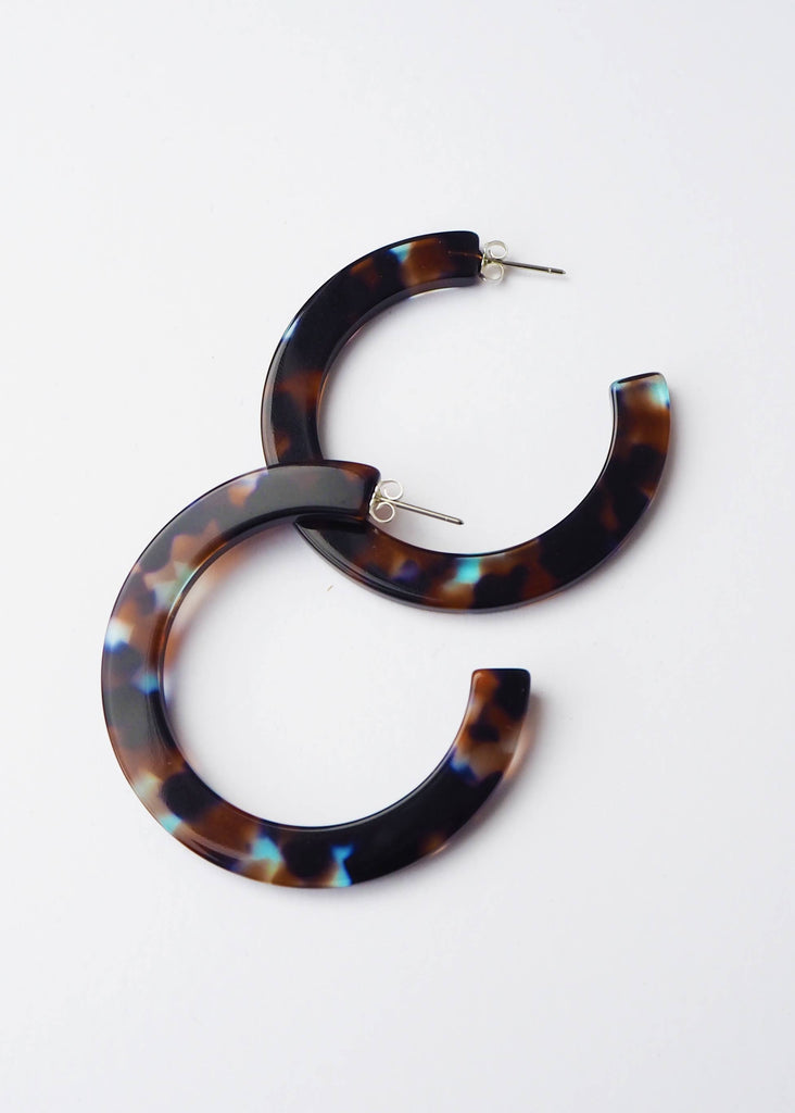 Tortoiseshell hoop earrings on a white background