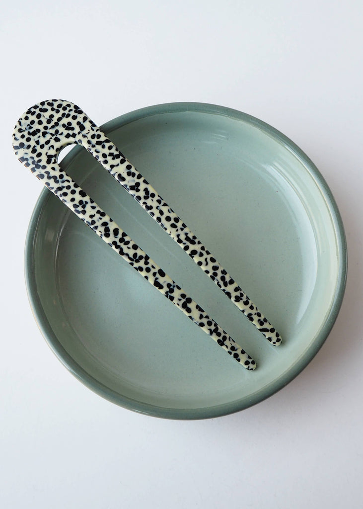 Hair clip with leopard print design on a green plate