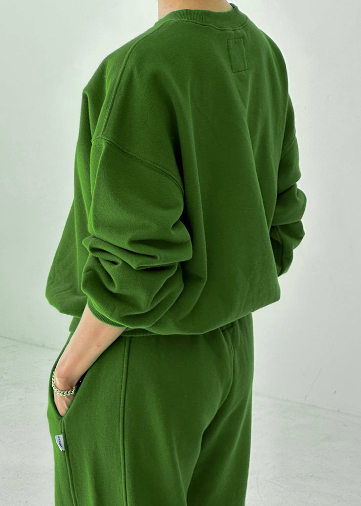 Person wearing a green tracksuit against a white background