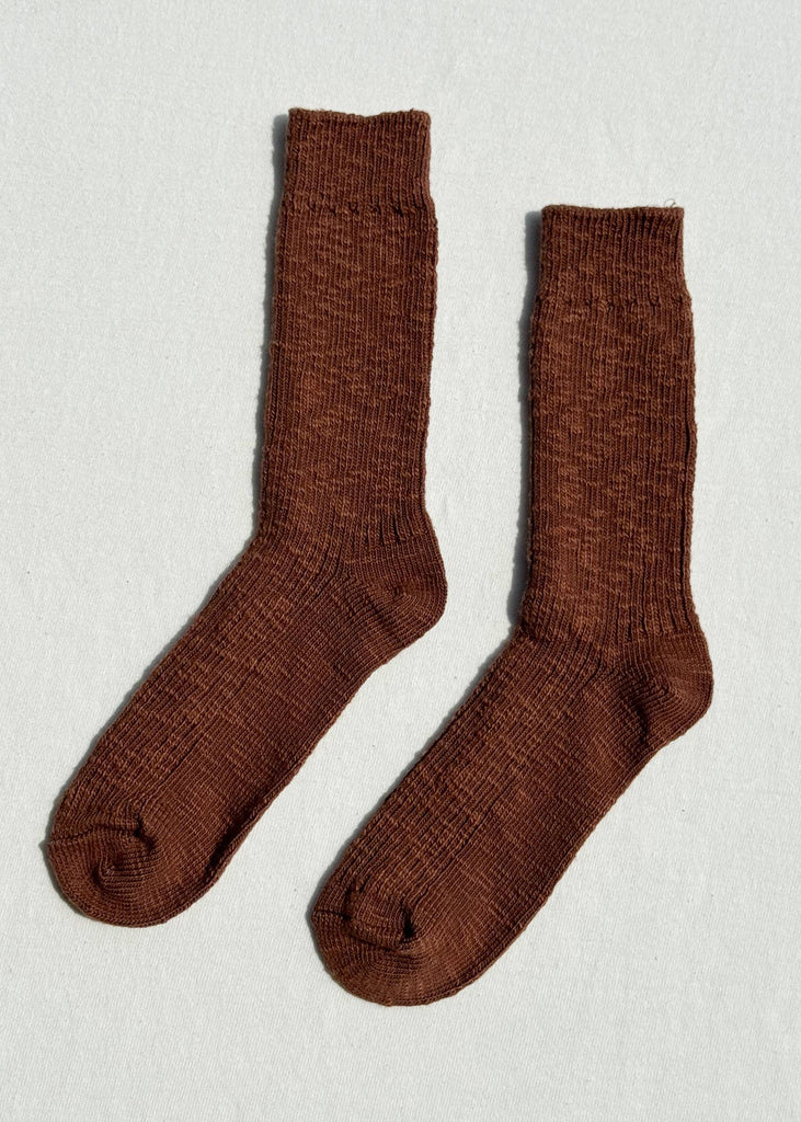 Pair of brown socks on a light gray background