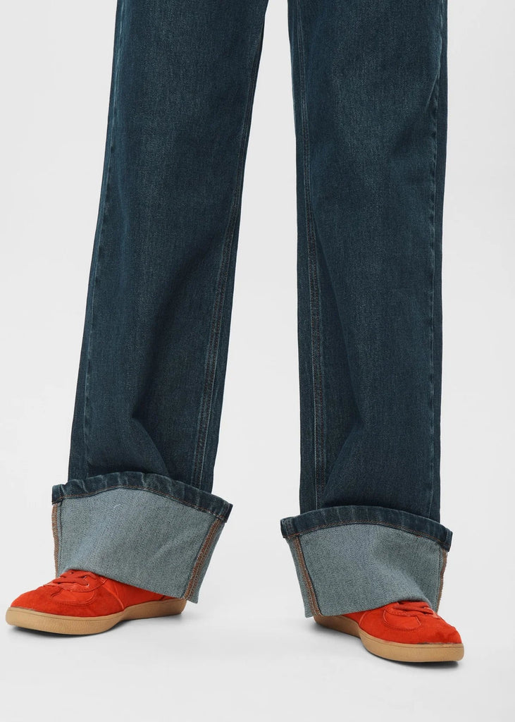 Cuffed jeans with red shoes on a white background