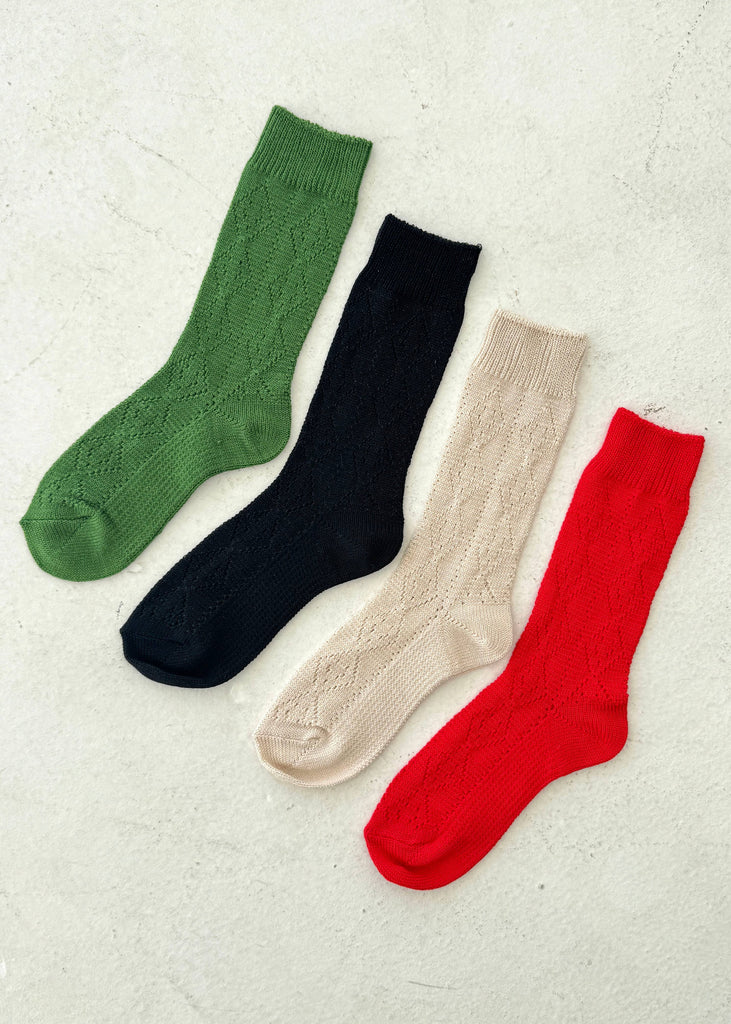 Four pairs of colorful socks (green, black, beige, red) on a light gray background.