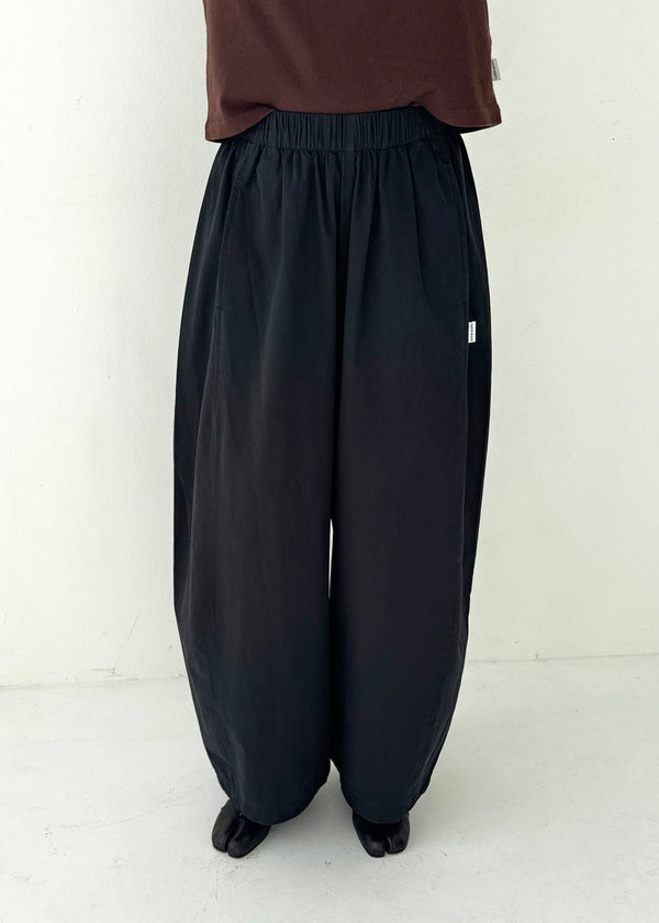Person wearing black wide-leg pants on a white background