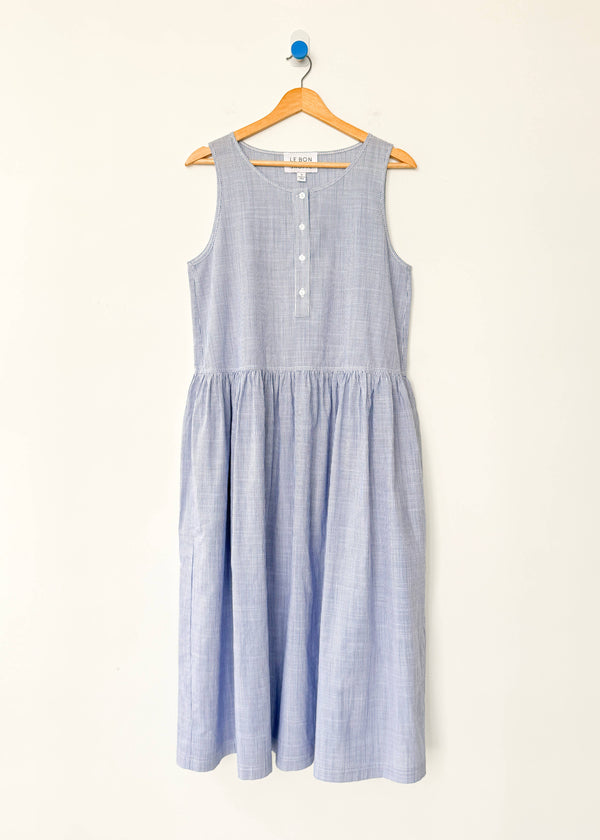 Blue striped dress on a hanger against a white background