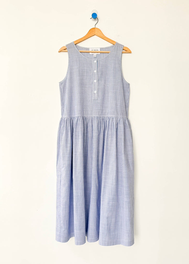 Blue striped dress on a hanger against a white background