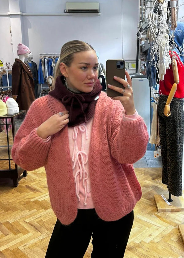 Person wearing a pink cardigan in a clothing store