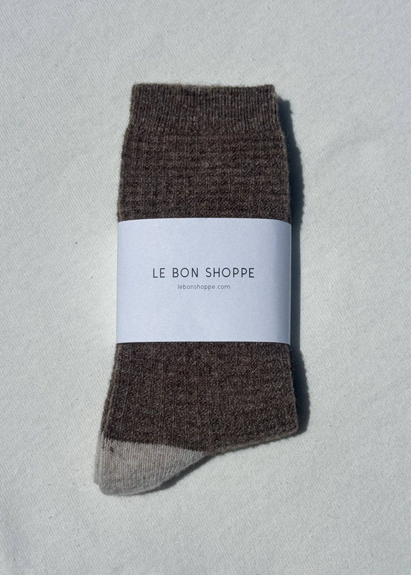Brown sock with a white label on a light gray background