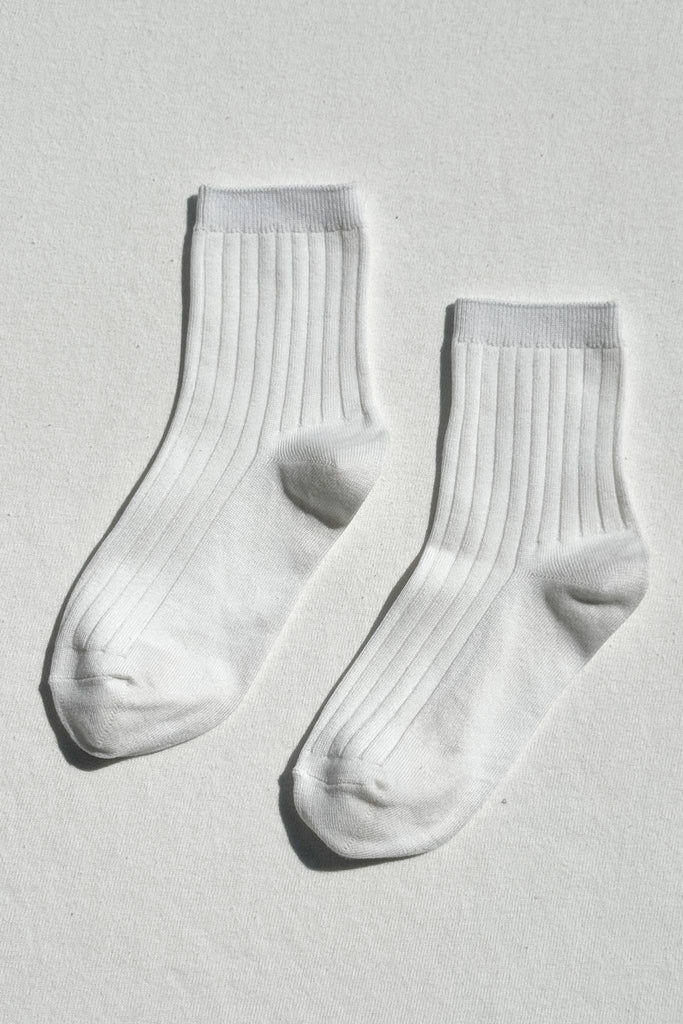 Pair of white socks on a light gray background