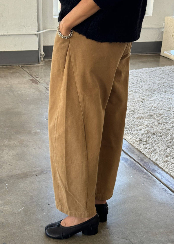 Person wearing beige pants and black shoes indoors.