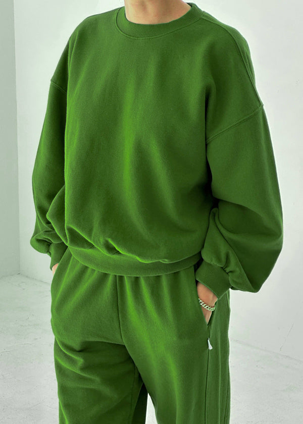 Person wearing a green tracksuit against a white background