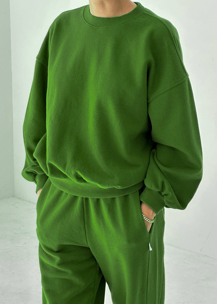 Person wearing a green tracksuit against a white background