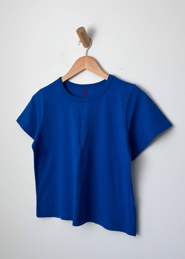 Blue t-shirt on a wooden hanger against a white background
