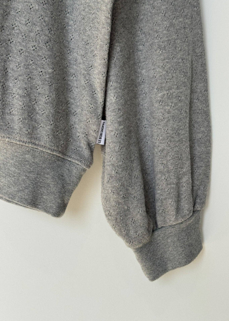 Gray sweatshirt with a brand tag on a white background
