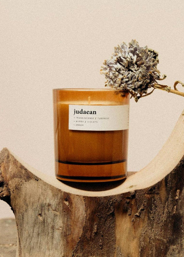 Candle with a 'judaean' label on a wooden surface