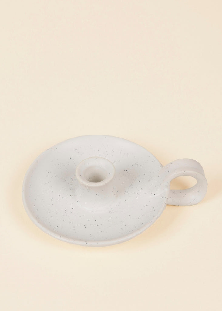 Speckled gray ceramic lid on a beige background