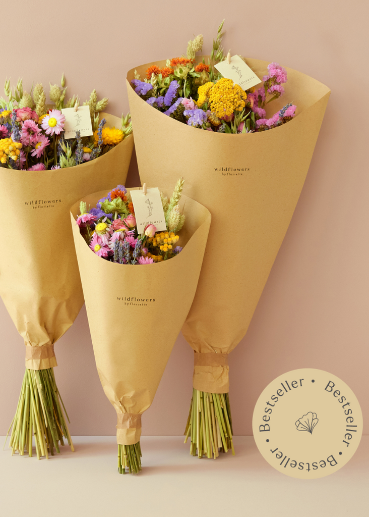 Three flower bouquets wrapped in brown paper with 'wildflowers' branding on a beige background.