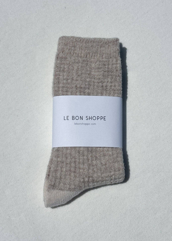 Pair of gray socks with a white label on a light gray background