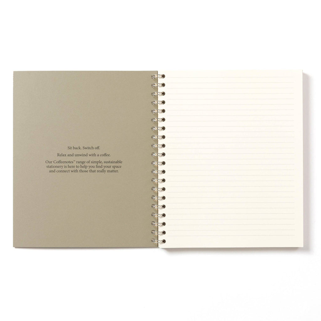 Open notebook with beige cover and white pages on a white background