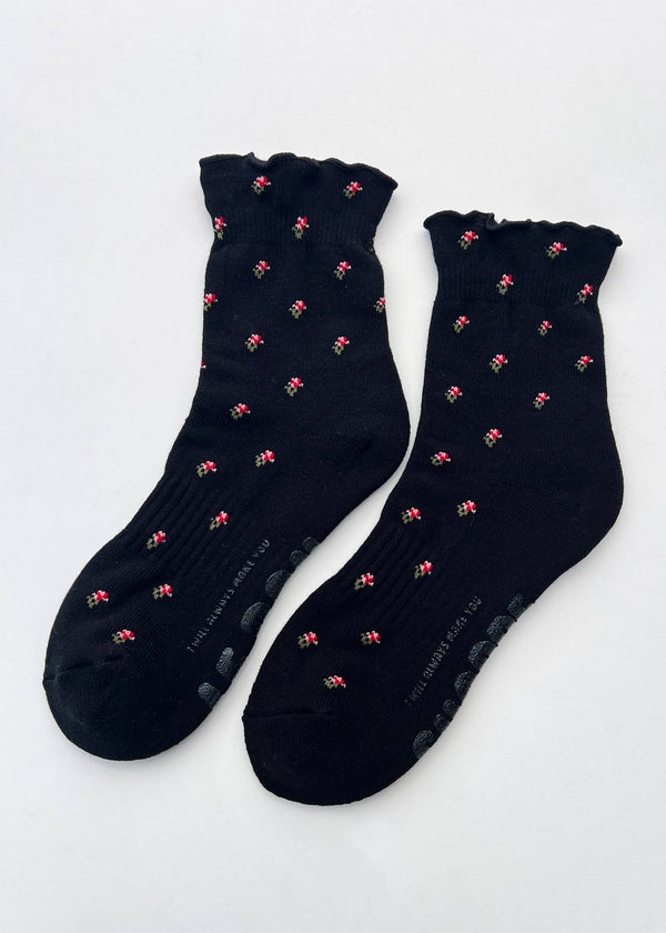 Pair of black socks with pink patterns on a white background