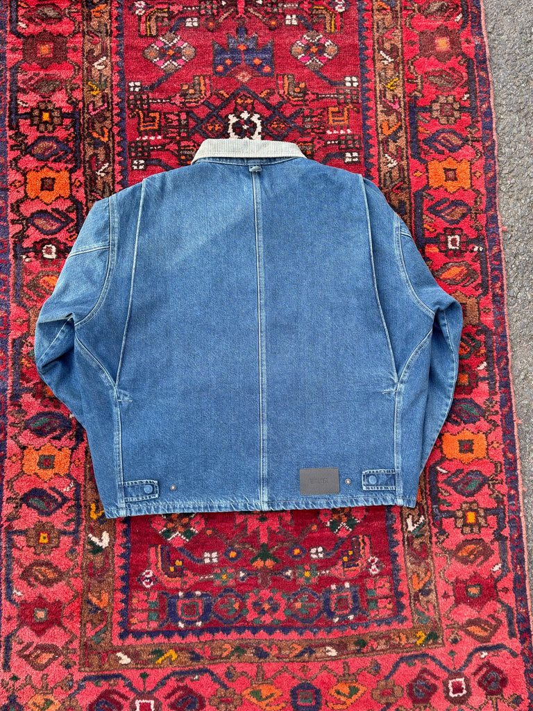 Blue denim jacket on a red patterned rug