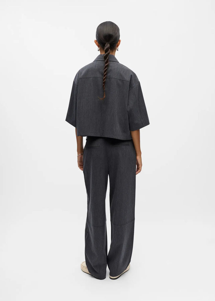 Person wearing a dark gray outfit on a white background