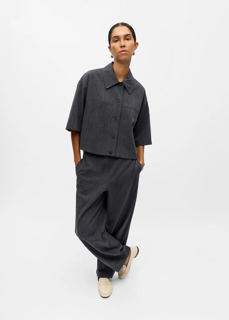 Person wearing a dark gray outfit on a white background