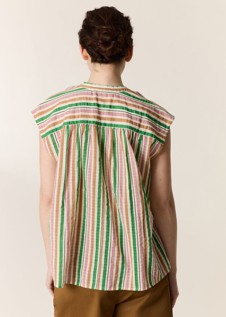 Person wearing a sleeveless striped shirt with a plain background