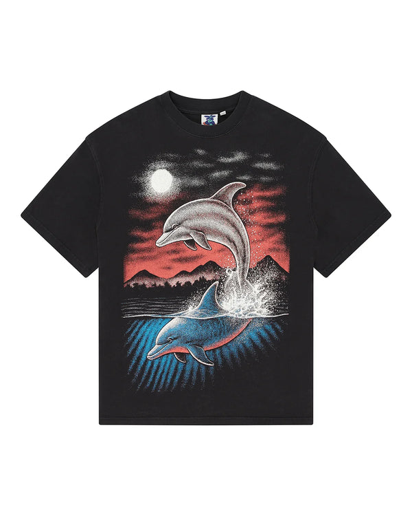 A black short-sleeve t-shirt featuring a large graphic print of two dolphins leaping from the water under a full moon and mountains, set against a plain white background.