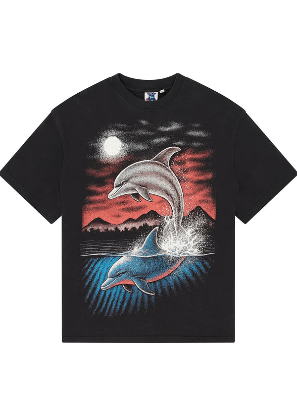 A black short-sleeve t-shirt featuring a large graphic print of two dolphins leaping from the water under a full moon and mountains, set against a plain white background.
