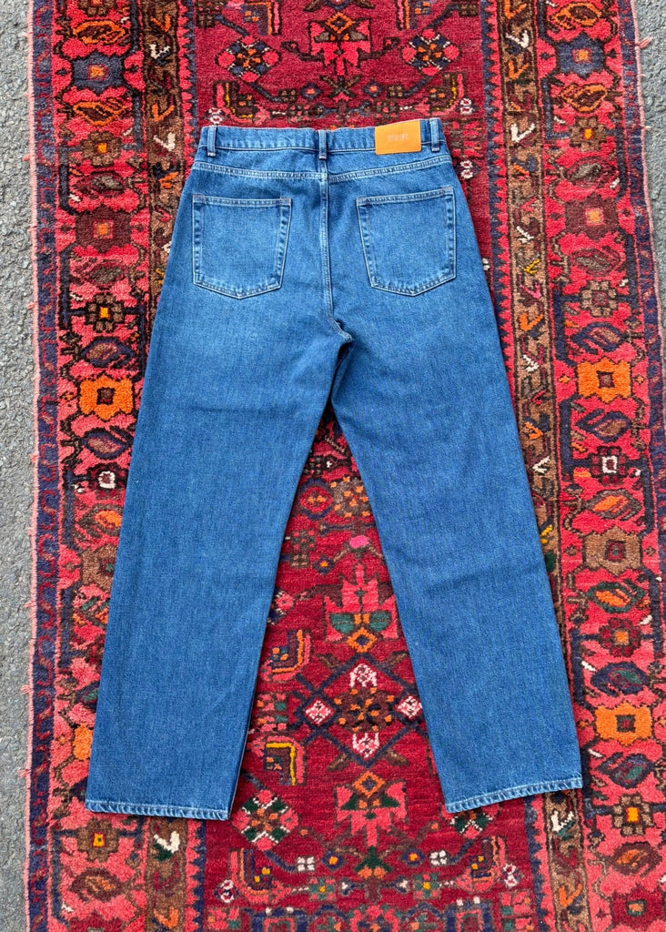 Blue jeans on a colorful patterned rug
