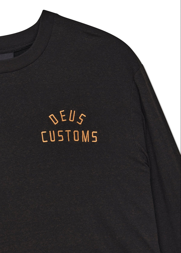 Black long-sleeve shirt with 'DEUS CUSTOMS' text in gold on a white background