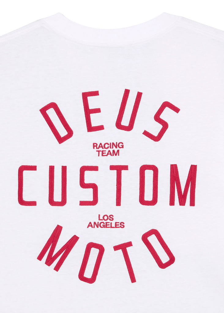 White t-shirt with red text 'DEUS CUSTOM MOTOR RACING TEAM LOS ANGELES' on a white background