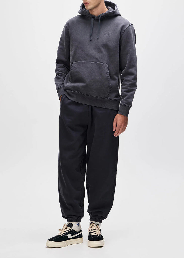 Person wearing a dark gray hoodie and matching pants on a white background