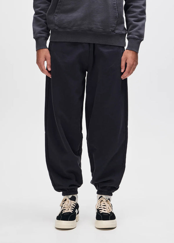 Person wearing black sweatpants and a dark hoodie on a white background