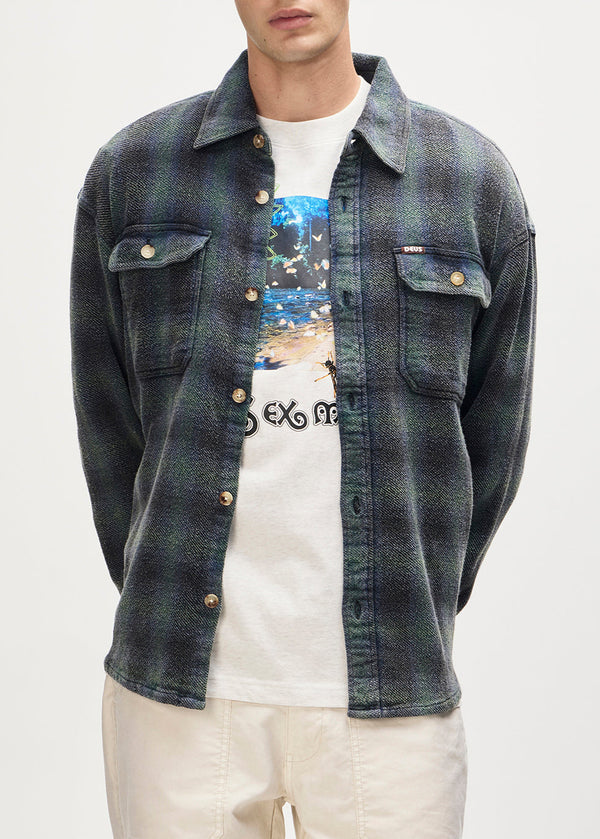Person wearing a denim jacket over a white t-shirt with graphic design on a plain background