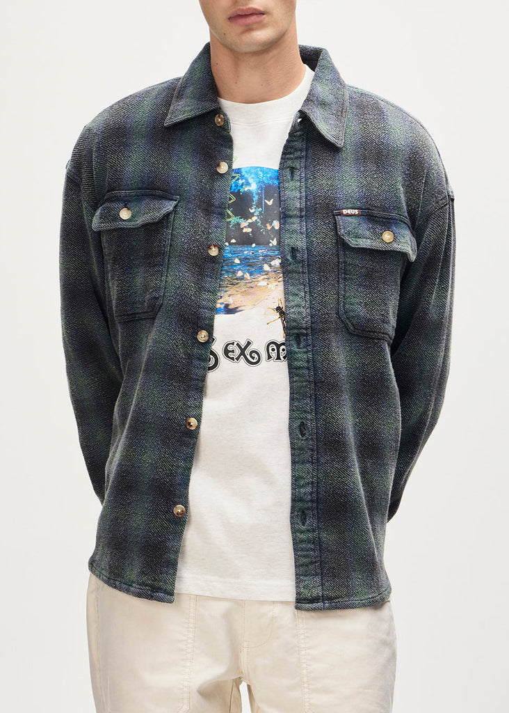Person wearing a denim jacket over a white t-shirt with graphic design on a plain background