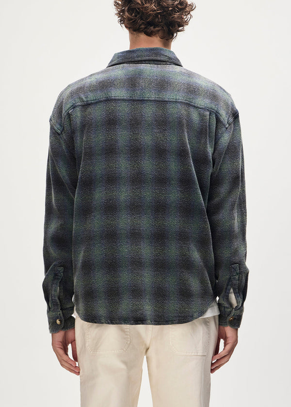 Person wearing a plaid shirt from behind on a plain background