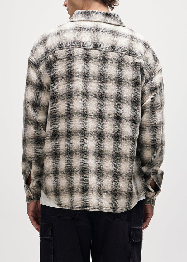 Person wearing a plaid shirt with a white background