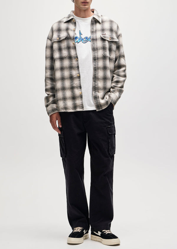 Person wearing a plaid shirt over a white t-shirt, black cargo pants, and black sneakers on a white background