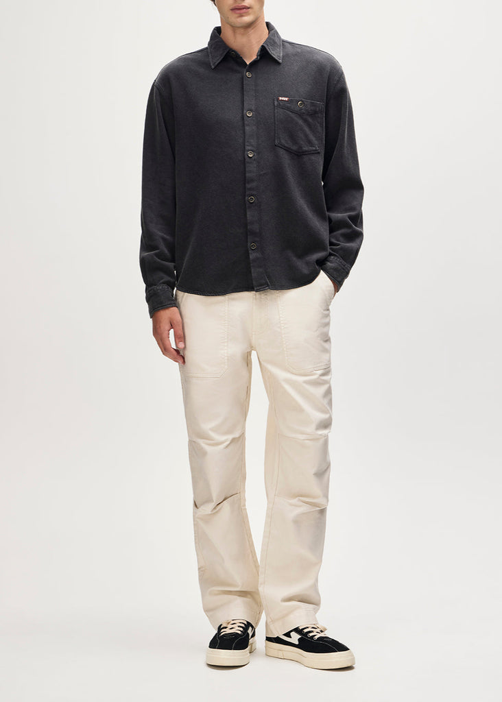 Person wearing a dark shirt and light pants on a white background