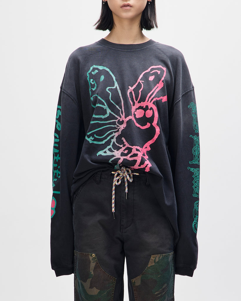 Person wearing a black sweatshirt with colorful butterfly design on a white background