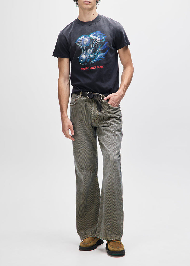 Person wearing a black t-shirt with a graphic design and gray pants on a white background