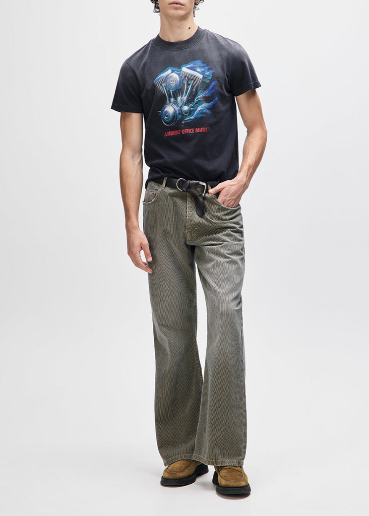 Person wearing a black t-shirt with a graphic design and gray pants on a white background