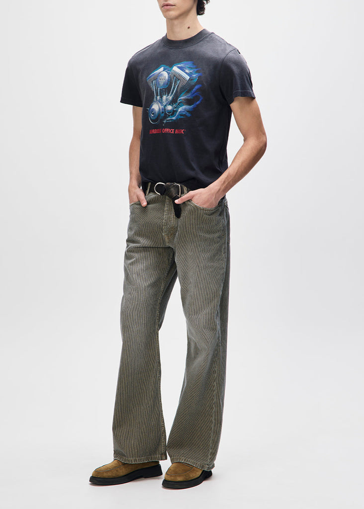 Person wearing a black t-shirt with graphic design and green pants on a white background