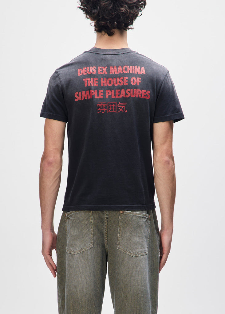 Person wearing a black t-shirt with red text on the back, standing against a plain background