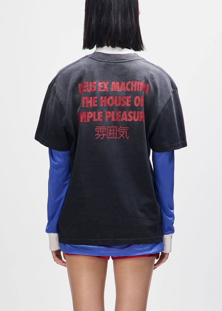 Person wearing a black and blue shirt with red text on the back against a white background