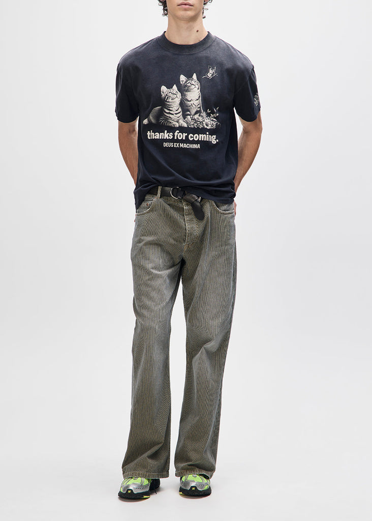 Person wearing a black t-shirt with graphic design and text, standing against a white background