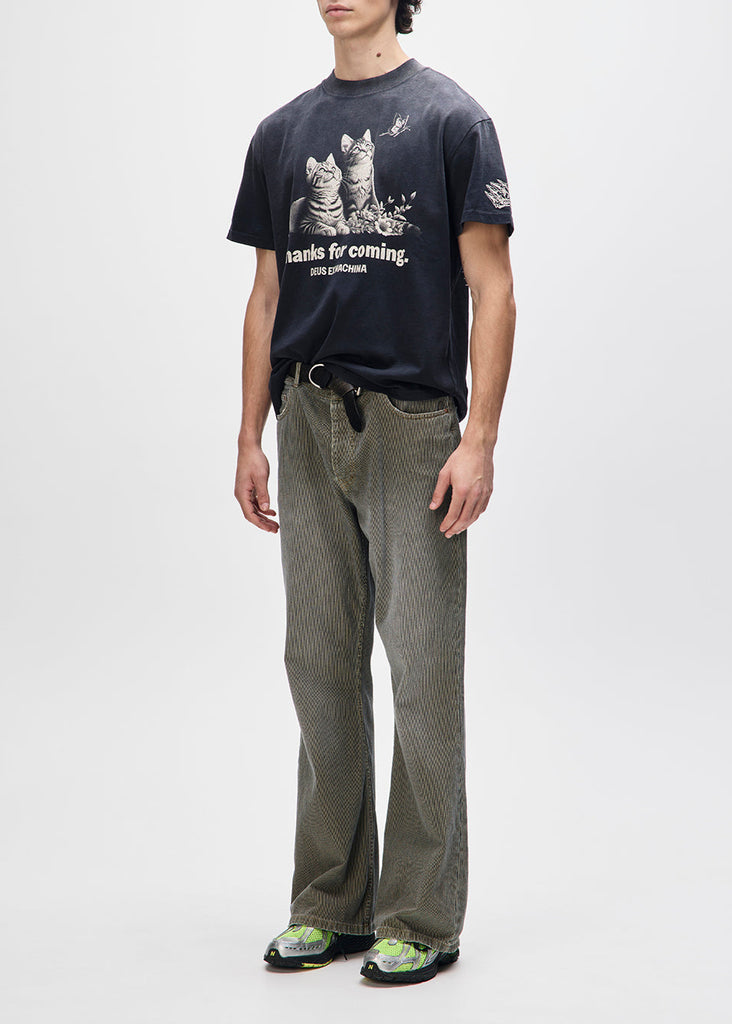 Person wearing a dark t-shirt with graphic designs and text, paired with patterned pants on a white background