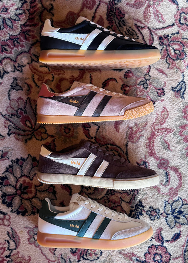 Four pairs of Gola shoes stacked on a patterned rug